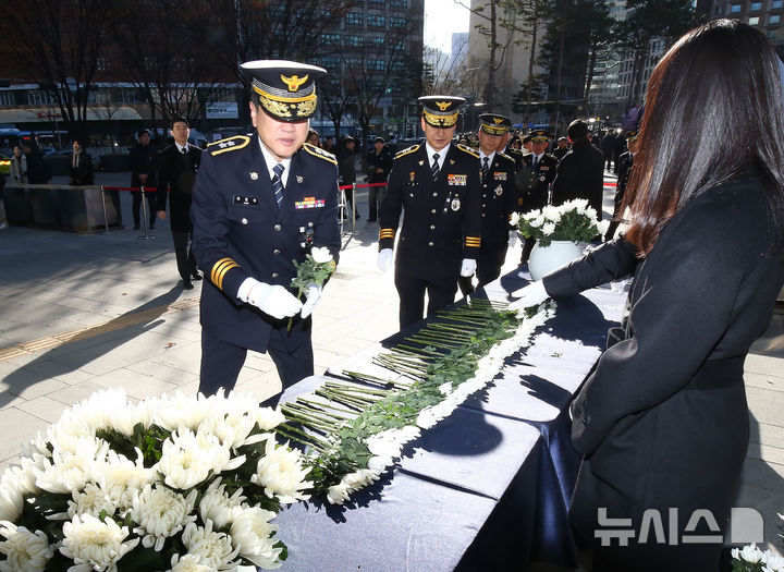 [서울=뉴시스] 고범준 기자 =서울시청 본관 앞에 마련된 제주항공 여객기 희생자 합동분향소를 찾은 경찰들이 헌화를 위해 꽃을 받고 있다. (공동취재) 2024.12.31. photo@newsis.com