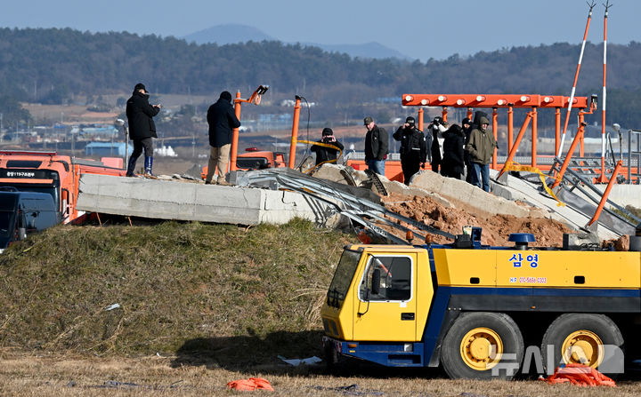 [무안=뉴시스] 류형근 기자 = 31일 오후 전남 무안군 무안국제공항 제주항공 여객기 참사 현장에서 한미합동조사단이 로컬라이저(착륙유도시설) 둔덕에 올라 콘크리트 잔해 등을 살펴보고 있다. 2024.12.31. hgryu77@newsis.com