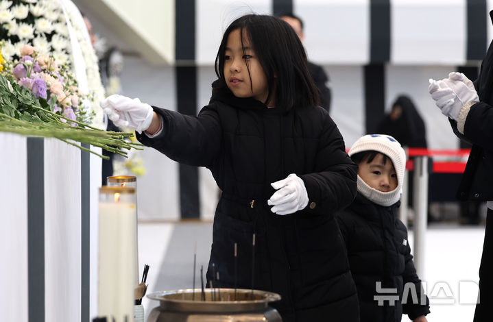 [대구=뉴시스] 이무열 기자 = 31일 대구 달서구 두류공원 안병근올림픽유도기념관에 마련된 제주항공 여객기 사고 희생자 합동분향소에서 어린이들이 헌화하고 있다. 2024.12.31. lmy@newsis.com