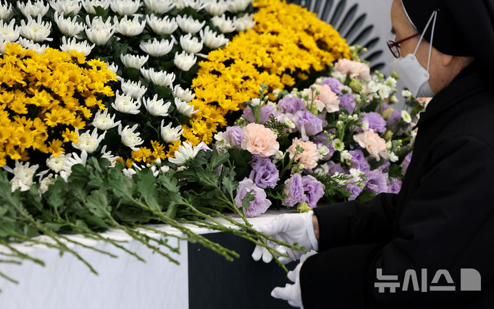 [대구=뉴시스] 이무열 기자 = 31일 대구 달서구 두류공원 안병근올림픽유도기념관에 마련된 제주항공 여객기 사고 희생자 합동분향소에서 한 수녀님이 헌화하고 있다. 2024.12.31. lmy@newsis.com