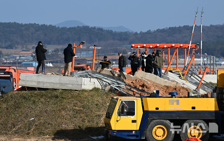 [무안=뉴시스] 류형근 기자 = 31일 오후 전남 무안군 무안국제공항 제주항공 여객기 참사 현장에서 항공철도사고조사위원회와 미국합동조사단이 로컬라이저(착륙유도시설) 둔덕에 올라 조사를 하고 있다. 2024.12.31. hgryu77@newsis.com