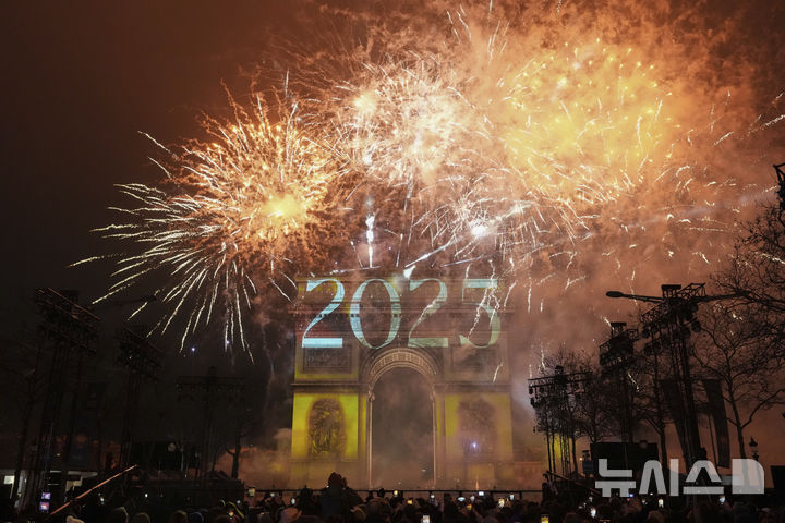 [파리=AP/뉴시스] 1일(현지시각) 프랑스 파리 샹젤리제 거리에서 새해 축하 행사가 열려 개선문 위로 불꽃놀이와 레이저 쇼가 펼쳐지고 있다. 2025.01.01.