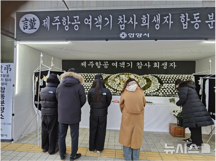 [안양=뉴시스] 박석희기자=을사년 첫날인 1일 오후 경기 안양시청 현관문 앞&nbsp; 광장에 마련된 제주항공 여객기 사고 희생자 합동분향소에서 일가족 4명이 희생자들을 애도하고 헌화를 하고 있다. 2025.01.01. phe@newsis.com
