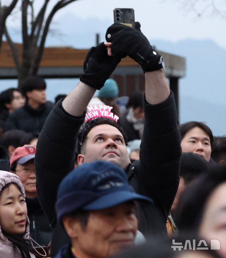 [서울=뉴시스] 추상철 기자 = 2025년 을사년(乙巳年) 새해가 밝은 1일 오전 서울 용산구 남산에서 외국인이 새해가 떠오르길 기다리고 있다. 2025.01.01. scchoo@newsis.com