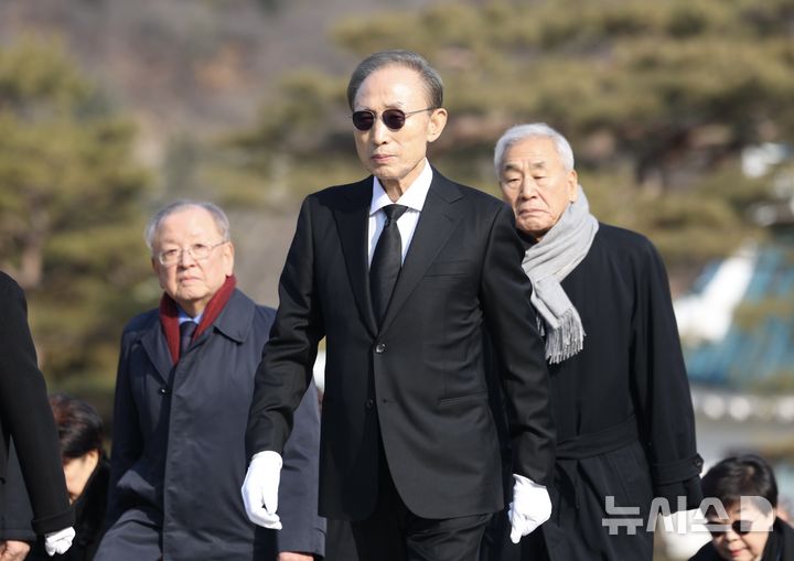 [서울=뉴시스] 김명년 기자 = 이명박 전 대통령이 재임 당시 함께했던 정부 인사들과 함께 새해 첫날인 1일 오전 서울 동작구 국립서울현충원 현충탑을 참배하기 위해 이동하고 있다. 2025.01.01. kmn@newsis.com