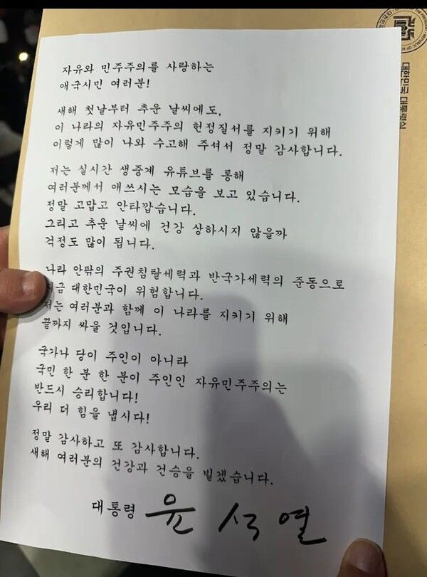 [서울=뉴시스] = 윤석열 대통령이 이틀째 철야집회 중인 지지자들에게 "실시간 생중계 유튜브를 통해 애쓰시는 모습을 보고 있다"며 "정말 고맙고 안타깝다"고 했다.윤 대통령은 이날 오후 7시30분께 서울 용산구 한남동 대통령 관저 앞 도로에서 철야집회를 하는 지지자들에게 직접 서명한 새해인사 및 감사인사글을 전했다.윤 대통령은 글에서 "자유와 민주주의를 사랑하는 애국시민 여러분! 새해 첫날부터 추운 날씨에도, 이 나라의 자유민주주의 헌정질서를 지키기 위해 이렇게 많이 나와 수고해 주셔서 정말 감사하다"고 밝혔다. (사진=석동현 변호사 제공) 2025.01.01. photo@newsis.com *재판매 및 DB 금지