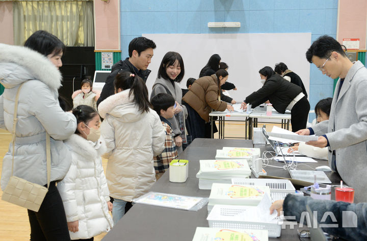 [울산=뉴시스] 배병수 기자 = 2025학년도 초등학교 신입생 예비소집일인 지난 1월 2일 울산 남구 옥동초등학교에서 입학을 앞둔 어린이가 부모와함께 입학 안내자료를 받고 있다. 2025.01.02.bbs@newsis.com.