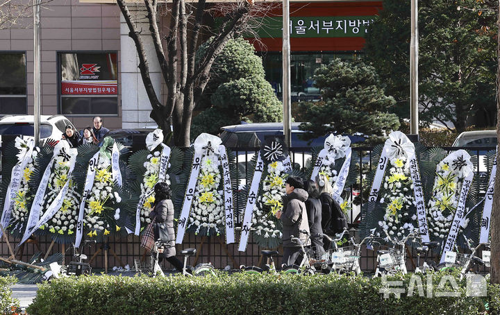 [서울=뉴시스] 김근수 기자 = 윤석열 대통령에 대한 체포영장을 발부한 서울서부지방법원 앞에 법원을 비난하는 근조화환이 설치된 2일 서울 마포구 서울서부지방법원 앞으로 한 시민들이 지나가고 있다. 2025.01.02. ks@newsis.com