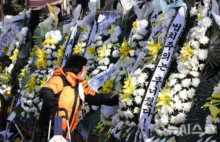 [서울=뉴시스] 김근수 기자 = 윤석열 대통령에 대한 체포영장을 발부한 서울서부지방법원 앞에 법원을 비난하는 근조화환이 설치된 2일 서울 마포구 서울서부지방법원 앞으로 한 시민이 지나가고 있다. 2025.01.02. ks@newsis.com