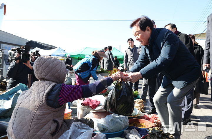 [창녕=뉴시스]3일 민생현장 점검차 창녕군 창녕읍 창녕상설시장을 찾은 박완수 경남도지사가 물품을 구입하고 있다.(사진=경남도 제공) 2025.01.03. photo@newsis.com