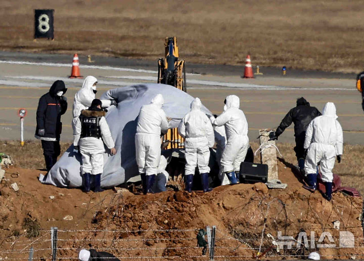 [무안=뉴시스] 김근수 기자 = 3일 전남 무안군 무안국제공항 제주항공 여객기 참사 현장에서 국가과학수사연구소와 미국합동조사단이 굴착기를 이용해 항공기 기체 엔진 조사를 하고 있다. 2025.01.03. ks@newsis.com