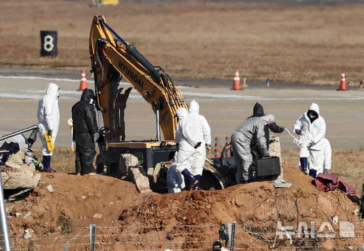 [무안=뉴시스] 김근수 기자 = 3일 전남 무안군 무안국제공항 제주항공 여객기 참사 현장에서 국가과학수사연구소와 미국합동조사단이 굴착기를 이용해 항공기 기체 엔진 조사를 하고 있다. 2025.01.03. ks@newsis.com