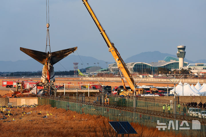 [무안=뉴시스] 김근수 기자 = 3일 전남 무안군 무안국제공항 제주항공 여객기 참사 현장에서 소방당국 관계자들이 크레인을 이용해 여객기 꼬리부분을 들어올리고 있다. 2025.01.03. ks@newsis.com