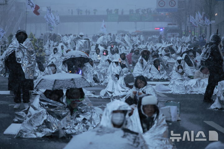 [서울=뉴시스] 정병혁 기자 = 5일 서울 용산구 대통령 관저 인근에서 열린 1박 2일 민주노총 철야투쟁에서 시민들이 은박 비닐을 덮은 채 참석해 있다. 2025.01.05. jhope@newsis.com