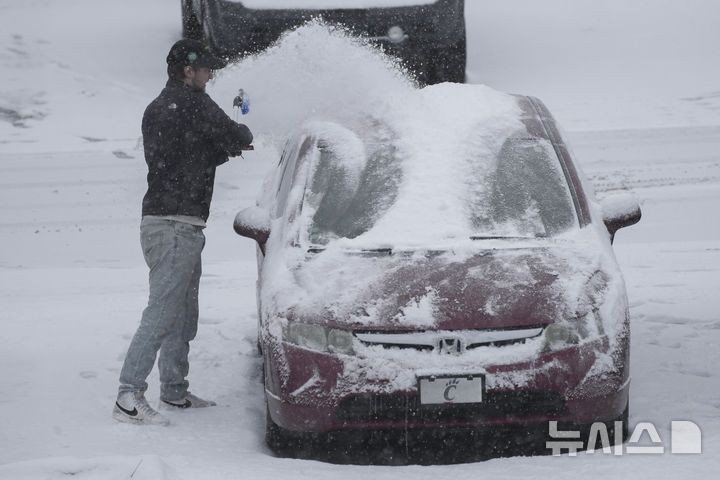 [신시내티(미 오하이오주)=AP/뉴시스]겨울 눈폭풍이 몰아친 미 오하이오주 신시내티에서 5일(현지시각) 한 남성이 두텁게 쌓인 자동차 위의 눈을 치우고 있다. 10년만에 가장 많은 눈을 몰고 올 위험이 큰 파괴적인 겨울 폭풍으로 미 중부 일부 주들에 눈과 얼음, 강풍, 기온 급락에 따른 교통 위험 상황이 야기된 가운데 뉴저지와 캔자스, 미주리, 켄터키, 버지니아, 웨스트 버지니아, 아칸소주 등 몇몇 주들이 비상사태를 선포했다고 BBC가 6일 보도했다. 2025.01.06.