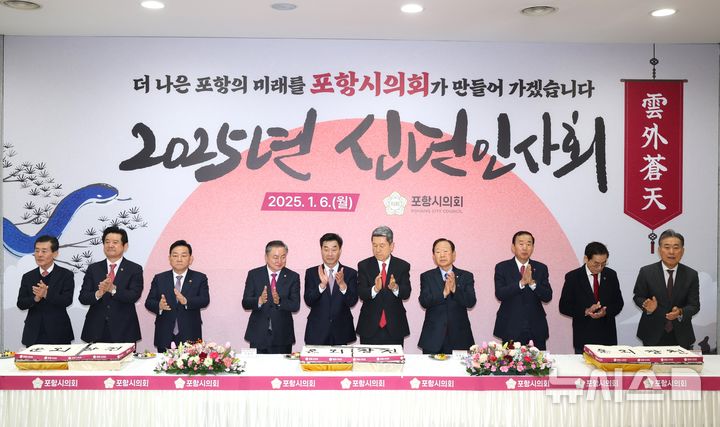 [포항=뉴시스] 송종욱 기자 = 6일 열린 포항시의회 신년 인사회에서 참석자들이 새해 덕담을 나누고, '운외창천(雲外蒼天·어두운 구름 밖으로 나오면 맑고 푸른 하늘이 나타난다)'이 새겨진 시루떡을 앞에 두고 기념 촬영을 하고 있다. (사진=포항시의회 제공) 2025.01.06. photo@newsis.com