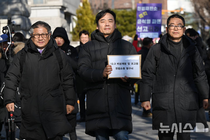 [서울=뉴시스] 전신 기자 = 7일 서울 종로구 헌법재판소 앞에서 윤석열즉각퇴진·사회대개혁 비상행동 회원들이 12.3 비상계엄 및 포고령 헌법소원 청구 기자회견을 마친 뒤 청구서를 제출하기 위해 민원실로 향하고 있다. (공동취재) 2025.01.07. photo1006@newsis.com