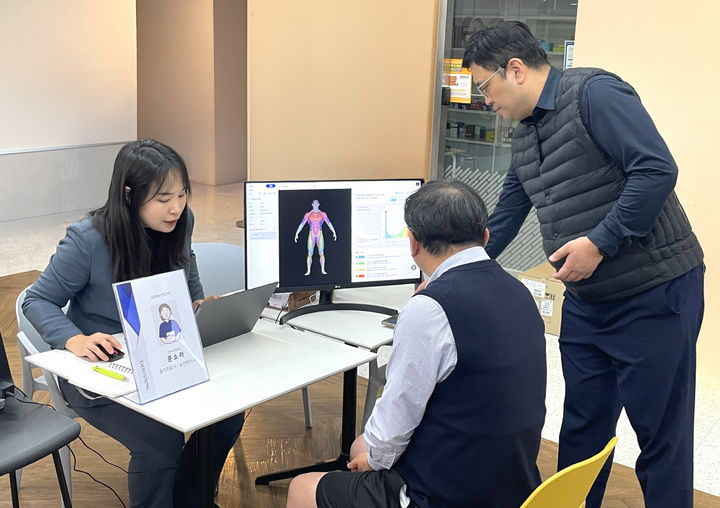 [서울=뉴시스] 대웅제약 임직원(가운데)이 AI 근감소증 진단기기를 이용해 검사를 받은 후, 근감소증 유병 여부를 확인하고 있다. (사진=대웅제약 제공) 2025.01.08. photo@newsis.com *재판매 및 DB 금지