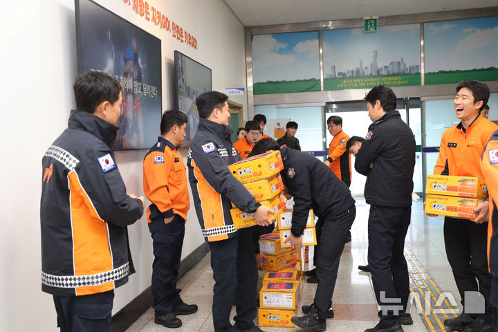 [성남=뉴시스] 성남 분당소방서 소속 소방대원들이 성남시로부터 격려품을 전달받고 있다 (사진=성남시 제공) 2024.01.08.photo@newsis.com