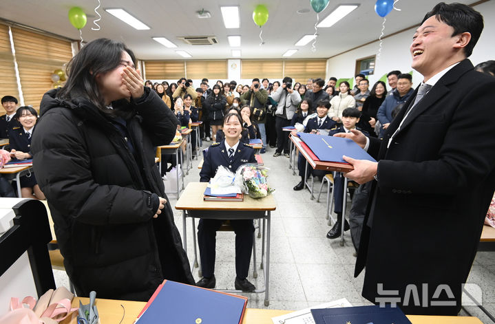 [수원=뉴시스] 김종택 기자 = 8일 경기도 수원시 삼일공업고등학교에서 열린 졸업식에서 경찰사무행정과 졸업생이 담임선생님으로부터 졸업장과 졸업 앨범을 전달 받으며 울먹이고 있다. 2025.01.08. jtk@newsis.com