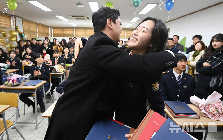 [수원=뉴시스] 김종택 기자 = 8일 경기도 수원시 삼일공업고등학교에서 열린 졸업식에서 경찰사무행정과 졸업생이 담임선생님으로부터 졸업장을 전달 받은 뒤 포옹하고 있다. 2025.01.08. jtk@newsis.com