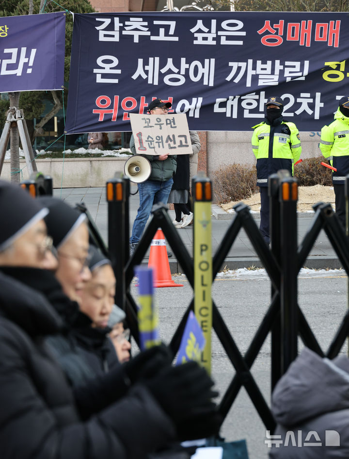 [서울=뉴시스] 김명원 기자 = 8일 서울 종로구 중학동에서 정의기억연대, 일본군 성노예제 문제해결을 위한 정기 수요시위가 진행되고 있는 가운데, 수요시위 맞은편에서 반대집회자가 확성기를 켜며 시위를 하고 있다. 수요시위 반대 집회 우선권을 보장한 인권위 권고가 '논란'이다. 국가인권위원회(인권위)는 지난 6일 일본군 '위안부' 수요시위와 같은 장소에서 집회를 열겠다고 한 반대 단체의 집회 우선권을 보장하라고 권고했다. 이 권고안은 수요시위의 역사적 의미를 고려해 이 집회를 적극 보호해야 한다는 인권위의 앞선 판단과 배치된다. 2025.01.08. kmx1105@newsis.com