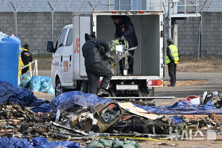 [무안=뉴시스] 이영주 기자 = 국토교통부 항공철도사고조사위원회 소속 감식반이 8일 오전 전남 무안군 무안국제공항 내 제주항공 여객기 참사 현장에서 사고 여객기 잔해물을 수거하고 있다. 2025.01.08. leey2578@newsis.com