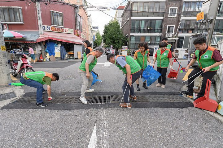 [서울=뉴시스] 지난 여름, 배수로 안에 쌓인 쓰레기를 줍고 있는 양천구 지역자율방재단. 2025.01.09. (사진=양천구 제공) *재판매 및 DB 금지