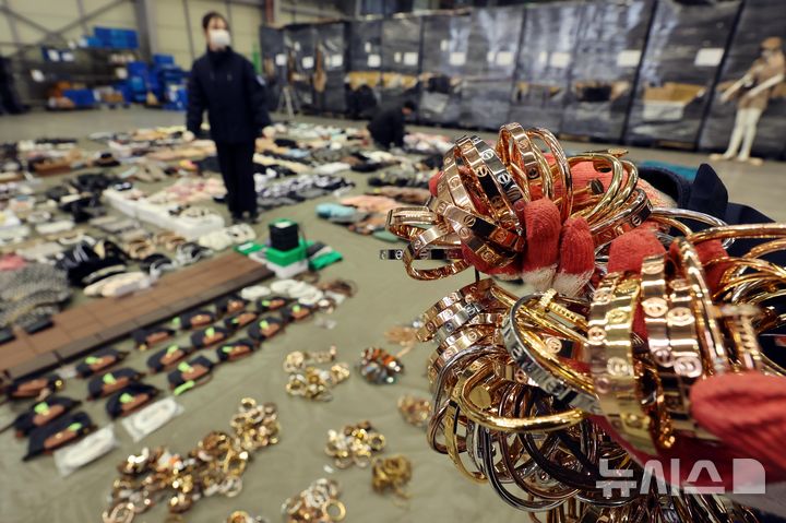 [부산=뉴시스] 하경민 기자 = 부산세관 직원들이 9일 부산 강서구 부산세관신항지정장치장에서 유통업자로부터 압수한 중국산 짝퉁 제품들을 정리하고 있다.&nbsp;&nbsp;&nbsp;&nbsp; 부산세관은 중국서 가방, 의류 등 시가 200억원 상당의 짝퉁 제품 1만여 점을 제작해 특송화물로 밀반입한 뒤 주택가 인근 원룸에 보관하며 온라인 쇼핑몰을 통해 판매한 전자상거래업체 대표 A(40대·여)씨를 관세법, 상표법, 범죄수익은닉의규제및처벌등에관한법률 위반 등의 혐의로 검찰에 불구속 송치했다고 밝혔다. 2025.01.09. yulnetphoto@newsis.com