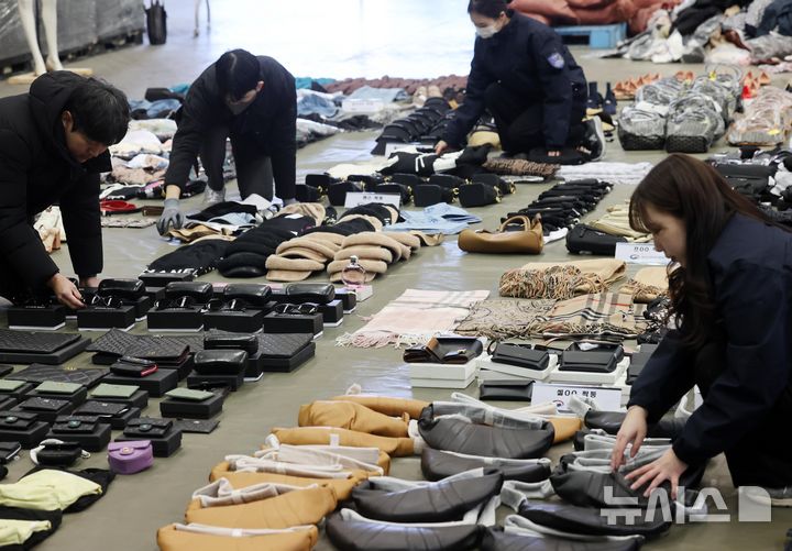 [부산=뉴시스] 하경민 기자 = 사진은 부산세관 직원들이 자난해 1월9일 부산 강서구 부산세관신항지정장치장에서 유통업자로부터 압수한 중국산 짝퉁 제품들을 정리하고 있는 모습. 2025.01.09. yulnetphoto@newsis.com