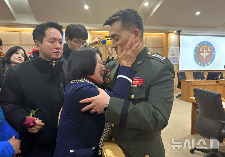 [서울=뉴시스] 이지민 수습기자 = 해병대 채상병 순직사건과 관련해 항명 및 상관명예훼손 혐의로 기소된 박정훈 전 해병대 수사단장(대령)이 지난 1월 서울 용산 중앙지역군사법원에서 열린 1심 선고공판에서 무죄를 선고 받은 뒤 모친 김봉순 여사로부터 축하를 받고 있다. 2025.01.09. ezmin@newsis.com