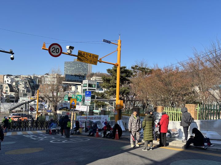 [서울=뉴시스] 우지은 기자 = 서울 용산구 한남초 교문 옆에 대통령 지지자들이 앉아 있다. 2025.01.10. now@newsis.com *재판매 및 DB 금지