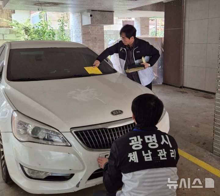 [광명=뉴시스]광명시 체납차량 담당 공직자들이 체납차량을 대상으로 번호판을 영치하고 있다. (사진=광명시 제공)2025.01.10.photo@newsis.com