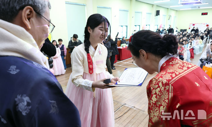 [서울=뉴시스] 김금보 기자 = 10일 오전 서울 종로구 서울재동초등학교에서 열린 한복 졸업식에서 학생이 졸업장을 받고 있다. 2025.01.10. kgb@newsis.com