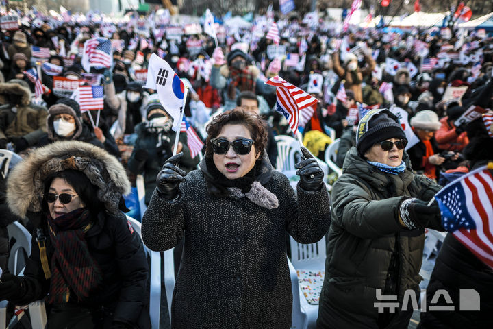 [서울=뉴시스] 정병혁 기자 = 11일 서울 종로구 동화면세점 앞에서 열린 대통령 탄핵 반대 집회에서 참가자들이 태극기와 성조기를 흔들며 구호를 외치고 있다. 2025.01.11. jhope@newsis.com