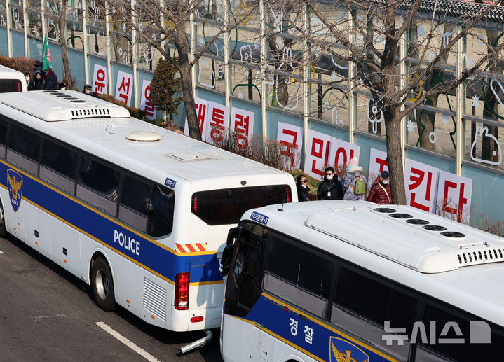 [서울=뉴시스] 이영환 기자 = 12일 오후 서울 용산구 윤석열 대통령 관저 인근 차벽 너머 인도에 지지자들이 가져다 놓은 피켓이 보이고 있다. 2025.01.12. 20hwan@newsis.com