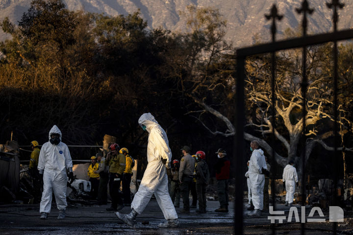 [알타데나=AP/뉴시스] 11일(현지 시간) 미국 캘리포니아주 알타데나에서 발생한 이튼 화재로 소실된 주택가에서 수색팀이 실종자 수색을 하고 있다. 2025.01.13.