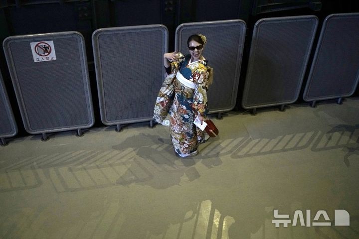 [요코하마=AP/뉴시스] 13일(현지 시간) 일본 요코하마에서 열린 성년의 날 기념식에 참석한 기모노 차림의 여성이 포즈를 취하고 있다. 2025.01.14.