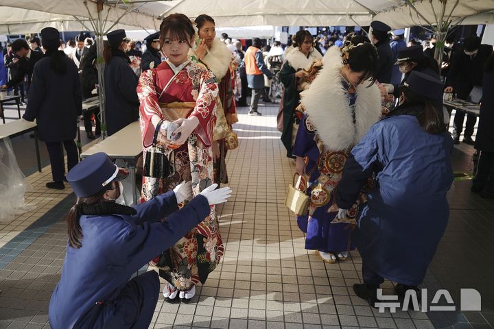 [요코하마=AP/뉴시스] 13일(현지 시간) 일본 요코하마에서 열린 성년의 날 기념식에 참석한 기모노 차림의 여성들이 검문을 받고 있다. 2025.01.14.