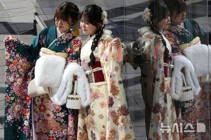 [요코하마=AP/뉴시스] 13일(현지 시간) 일본 요코하마에서 열린 성년의 날 기념식에 참석한 기모노 차림의 여성들이 기념촬영 하고 있다. 2025.01.14.