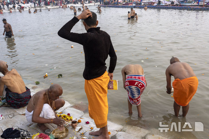 [프라야그라지(인도)=AP/뉴시스] 인도 북부 우타르프라데시주 프라야그라지에서 13일 개막한 힌두교 '쿰브 멜라' 축제 참가자들이 갠지스강과 야무나강, 신화 속 사라스와티강 등 세 개의 신성한 강이 합류하는 지점에서 물에 몸을 들어가 윤회를 끊는 의식을 갖고 있다. 2025.01.14. 