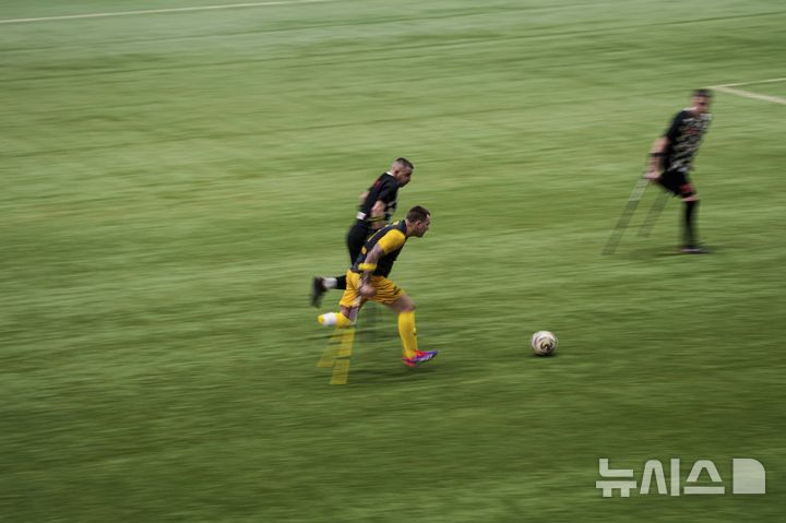 [키이우=AP/뉴시스] 12일(현지 시간) 우크라이나 키이우에서 열린 우크라이나 최초 절단 장애인 축구 선수권 대회에 참가한 선수들이 볼다툼을 하고 있다. 이들은 러시아-우크라이나 전쟁에서 신체 한 부분을 잃은 사람들로 각 팀 당 6명의 스트라이커와 1명의 골키퍼로 구성됐다. 2025.01.14.