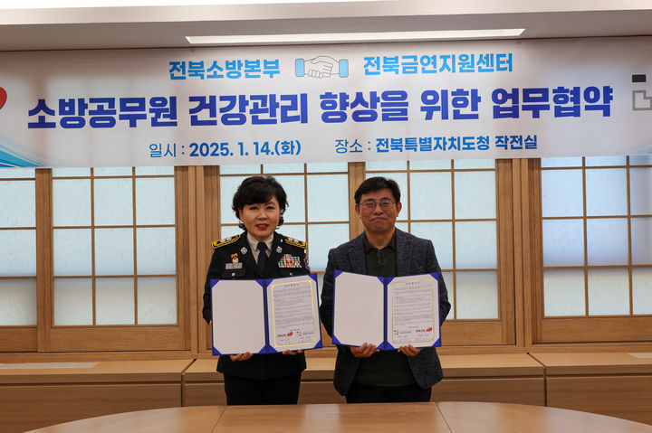 [전주=뉴시스] 14일 전북 전주시 전북특별자치도청 17층 작전실에서 열린 '소방공무원 건강관리를 위한 업무협약 체결식'에서 이오숙 전북특별자치도소방본부장(왼쪽)과 오경재 전북금연지원센터장이 협약식을 기념해 사진촬영을 하고 있다. (사진=전북특별자치도소방본부 제공) 2025.01.14. photo@newsis.com *재판매 및 DB 금지