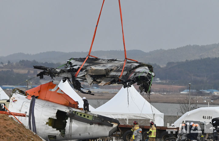 [무안=뉴시스] 김혜인 기자 = 15일 오후 제주항공 여객기 참사가 발생한 무안공항에서 중장비가 사고 기체 잔해를 들어올리고 있다. 2025.01.15. hyein0342@newsis.com