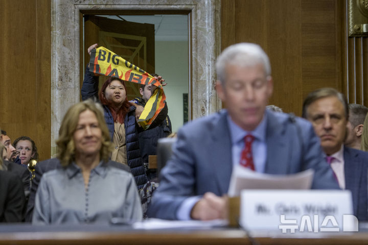 [워싱턴=AP/뉴시스]기후변화 시위대가 크리스 라이트 미국 차기 에너지부 장관 지명자의 15일(현지시각) 상원 에너지·천연가스위원회 청문회에 난입해 현수막을 흔들고 있다. 2025.01.16.