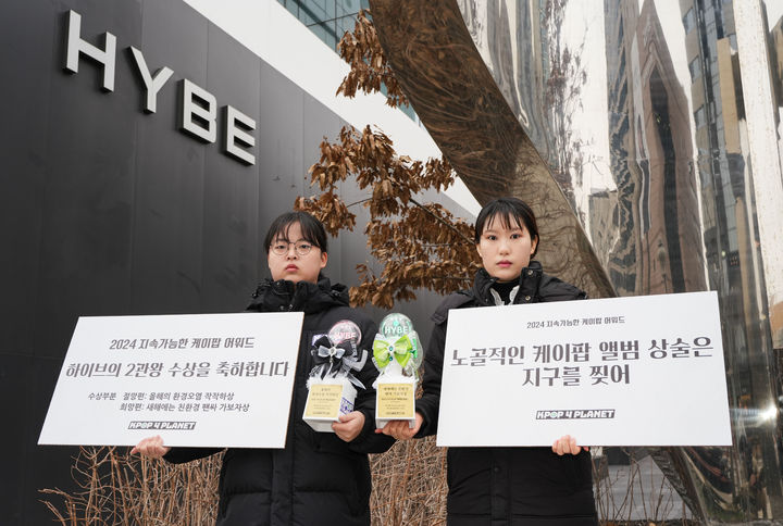 [서울=뉴시스] 조성봉 기자= 전 세계 케이팝 팬들이 결성한 '케이팝포플래닛' 회원들이 16일 서울 용산구 하이브 사옥 앞에서 ‘환경파괴적인 앨범 중복구매 상술 중단 촉구’ 퍼포먼스를 하고 있다. 케이팝포플래닛은 엔터사들이 플라스틱 오염을 유발하고 기후위기를 심화하는 상술을 중단하고, 지속가능한 미래를 위해 사회적 책임을 다할 것을 요구했다. (사진=케이팝포플래닛 제공)2025.01.16.photo@newsis.com *재판매 및 DB 금지