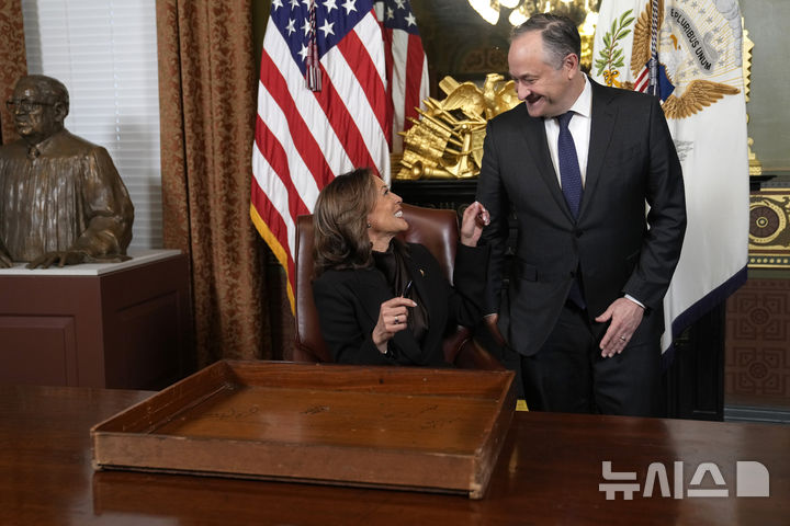 [워싱턴=AP/뉴시스] 카멀라 해리스(왼쪽) 부통령이 16일(현지 시간) 백악관 내 아이젠하워 행정청사 부통령 의전 사무실에서 백악관 전통에 따라 서랍에 서명한 뒤 남편 더그 엠호프와 대화하고 있다. 오는 20일 퇴임을 앞둔 해리스 부통령은 직원들에게 고마움을 전하며 1940년대부터 이어져 온 전통인 '서랍 서명'을 했다. 2025.01.16.