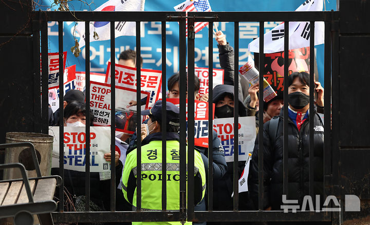 [서울=뉴시스] 김근수 기자 = 내란 수괴와 직권남용 등의 혐의를 받는 윤석열 대통령의 구속 전 피의자 심문(영장실질심사)이 열린 18일 서울 마포구 서울서부지방법원에서 윤 대통령 지지자들이 담장 너머에서 구호를 외치고 있다. (공동취재) 2025.01.18. photo@newsis.com