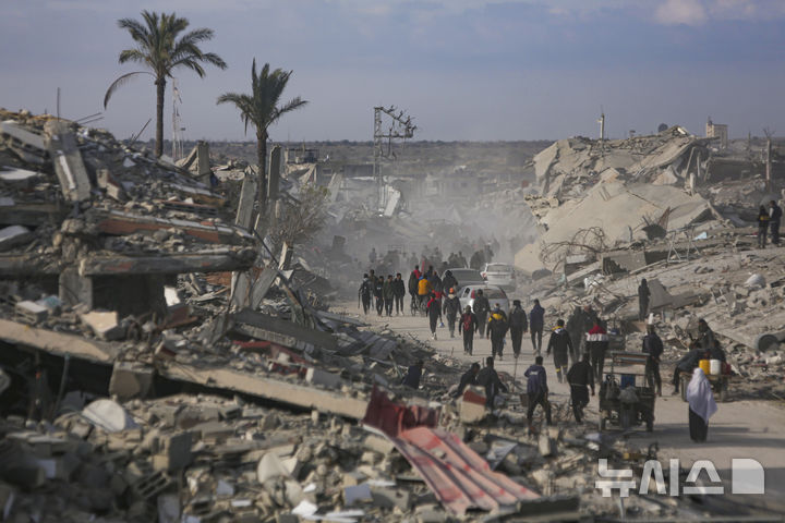 [AP/뉴시스] 가자 지구 휴전이 발효된 19일 중남부 칸유니스에 피난해 살고 있던 주민들이 고향인 남단 라파로 걸어 내려가고 있다. 