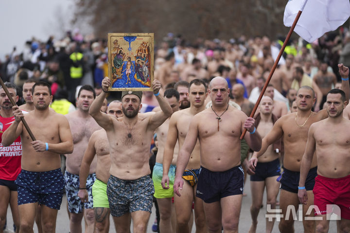 [베오그라드=AP/뉴시스] 19일(현지 시간) 세르비아 베오그라드에서 주현절 기념행사가 열려 정교회 신자들이 십자가를 찾기 위해 다뉴브강에 뛰어 들기 위해 이동하고 있다. 이날 동방 정교회 사제가 물에 던진 나무 십자가를 찾아오는 사람뿐 아니라 이를 찾기 위해 물에 뛰어든 사람 모두가 일 년 내내 건강하게 지낼 수 있다고 믿는다. 2025.01.20.